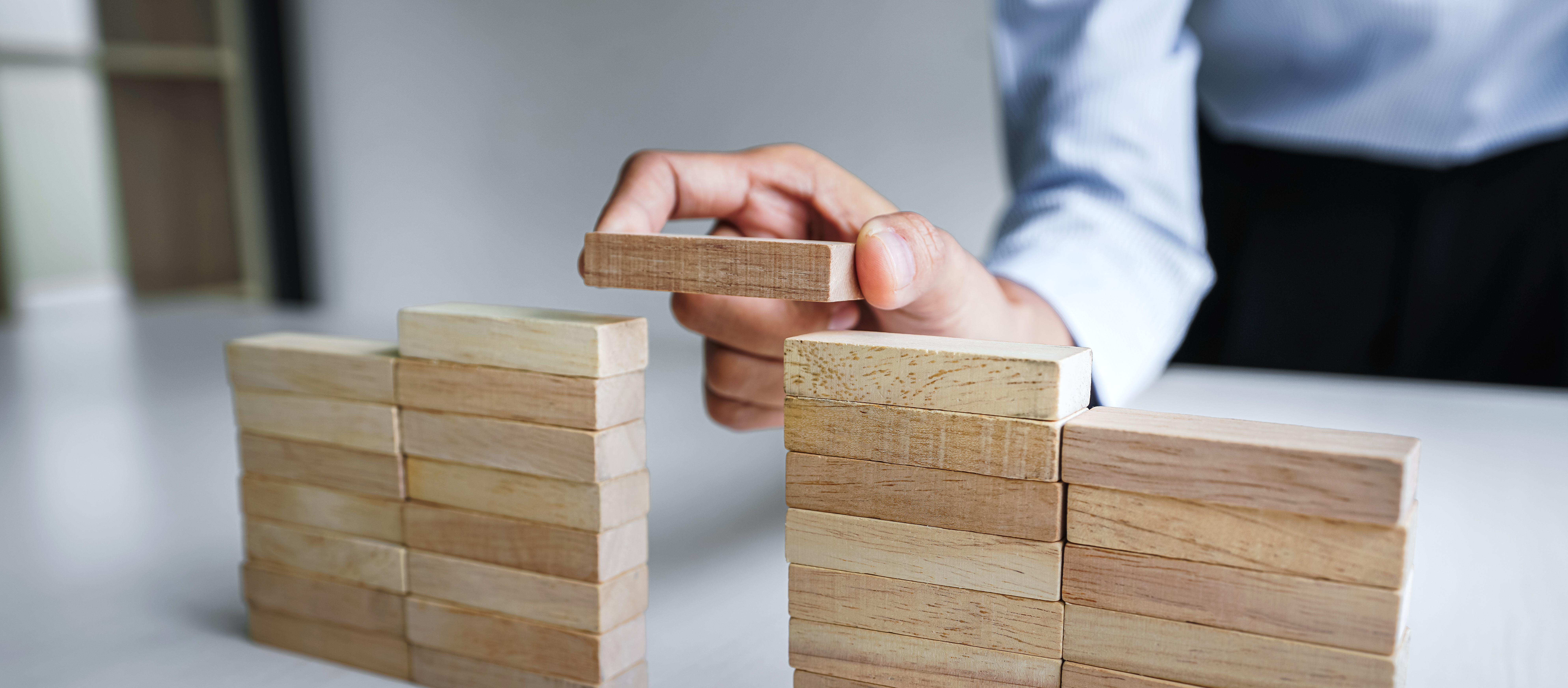 Plan and strategy in business, Risk To Make Business Growth Concept With Wooden Blocks, hand of man has piling up and stacking a wooden block.